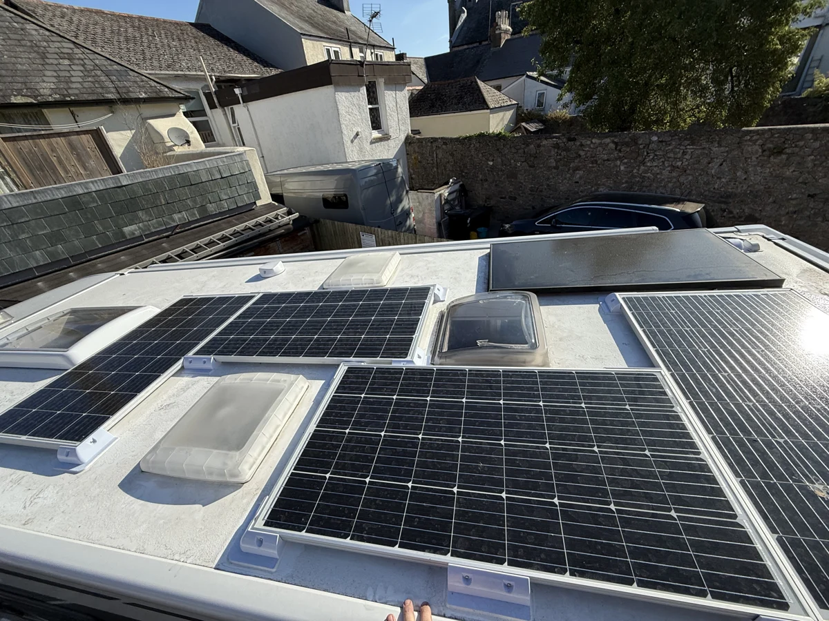 Solar panels installed on a vehicle roof around rooflights