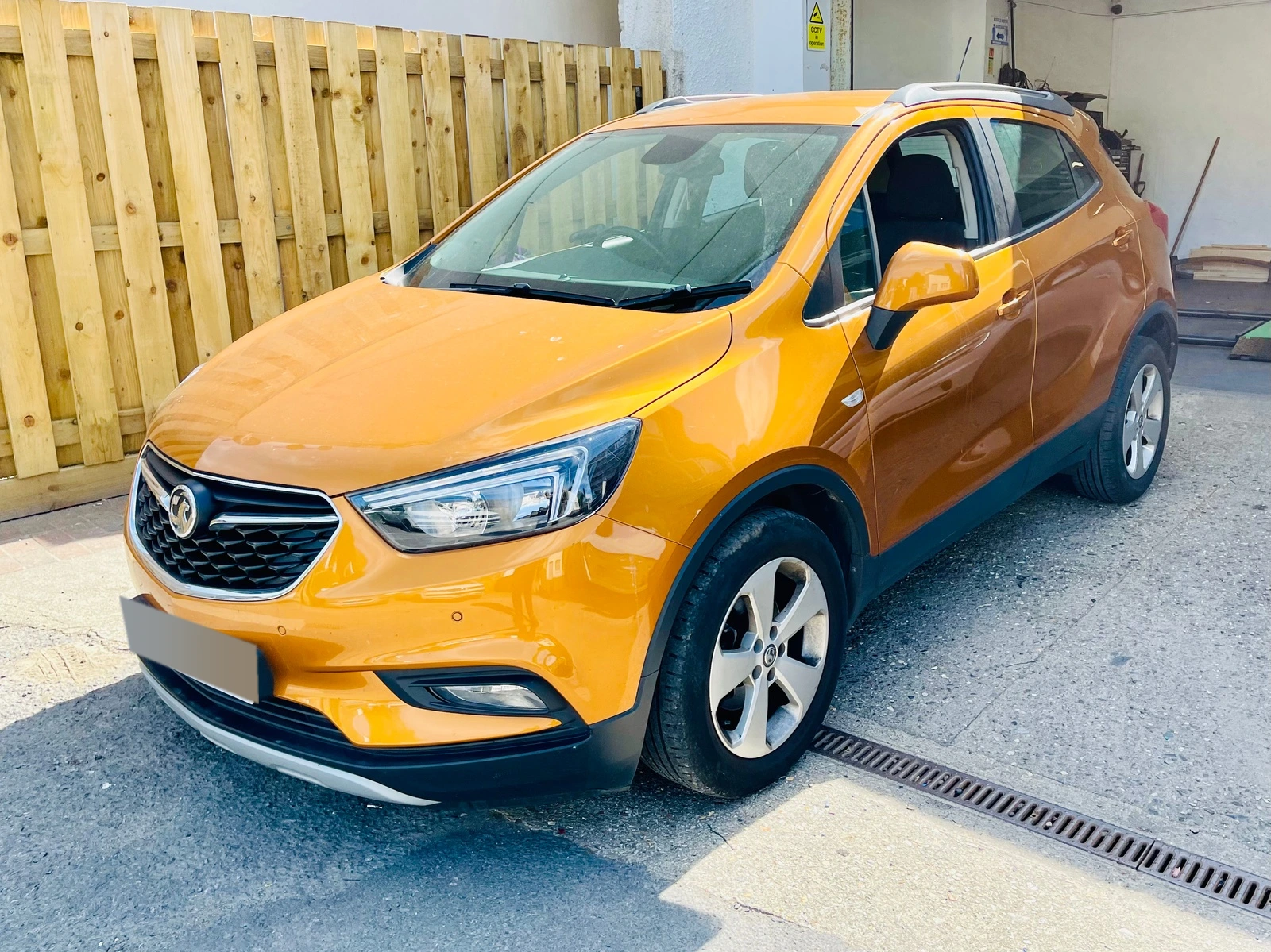 Orange Vauxhall Mokka outside the workshop