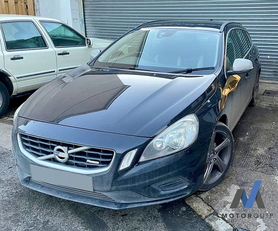 Front view of a dark Volvo parked outside the workshop