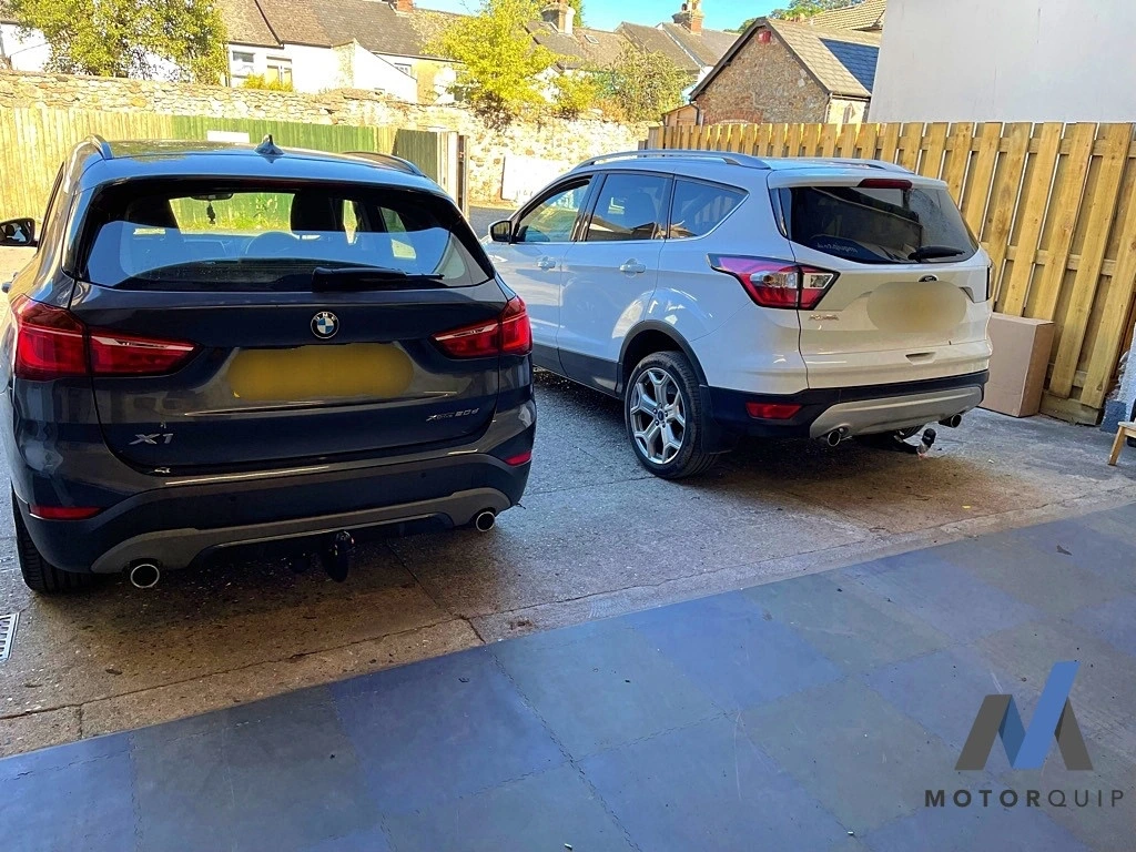 Rear views of a BMW and Ford showing their fitted towbars