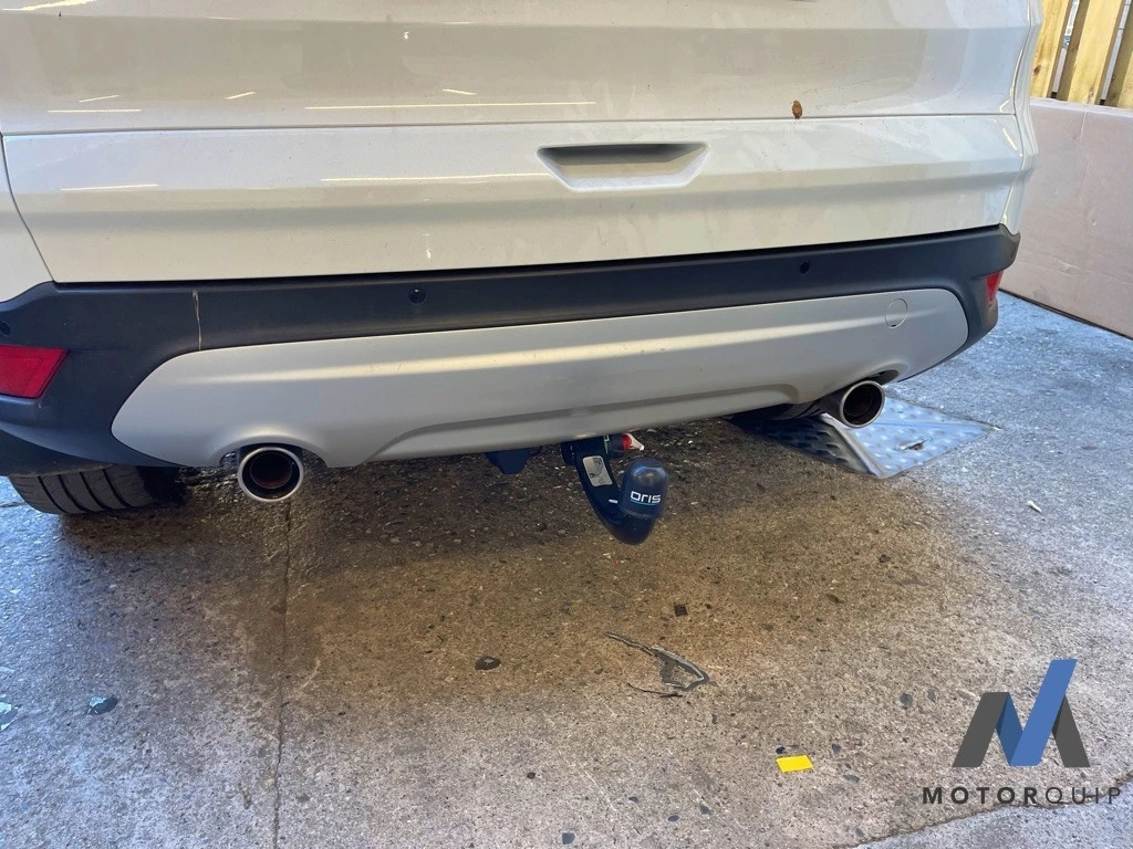 Towbar fitted beneath the rear bumper of a white Ford